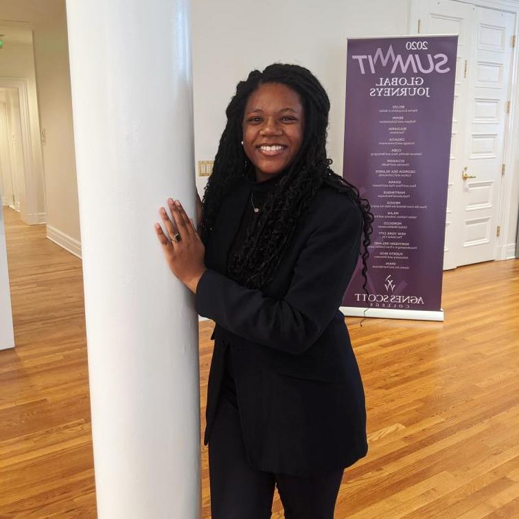 photo of smiling girl with SUMMIT banner in background